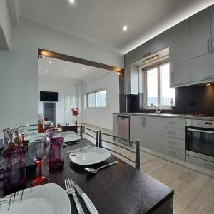 a kitchen with a table with plates and wine glasses at Zoggos Apartment in Áyios Pétros