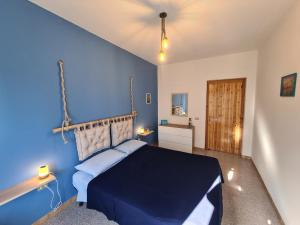 een blauwe slaapkamer met een bed en een blauwe muur bij A ca' di Pe e Giò in Calasetta