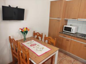 een keuken met een tafel met een magnetron en bloemen erop bij APARTAMENT CAN MINGU 2on pis in Besalú
