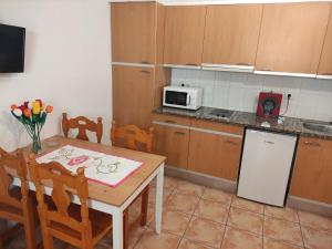 una pequeña cocina con mesa y microondas en APARTAMENT CAN MINGU 2on pis, en Besalú