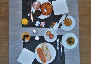 a table with plates of breakfast foods and a cup of coffee at Estudiotel Alicante in Alicante