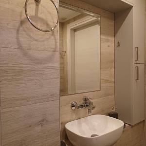 a bathroom with a white sink and a mirror at Zoggos Apartment in Áyios Pétros +26 photos