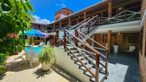 Un escalier mène à une maison avec une terrasse. dans l'établissement Pousada Lua Cheia, à Praia do Frances