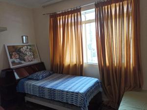 a bedroom with a bed in front of a window at Quarto no Centro de Juiz de Fora in Juiz de Fora