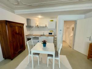 a white kitchen with a white table and chairs at Lauben Suite Old Town Bolzano in Bolzano +14 photos