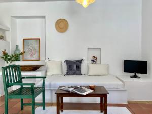sala de estar con sofá, mesa y silla en Alkyonis Villas, en Kamarai