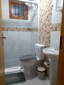 a bathroom with a shower and a toilet and a sink at Casa e Flat Conforto Gramado in Gramado