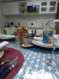 una mesa con platos y utensilios encima en Casa e Flat Conforto Gramado en Gramado