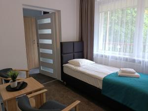 1 dormitorio con cama, mesa y ventana en Rewita Pieczyska, en Koronowo