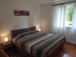 a bedroom with a bed with two lamps on it at Apartment Brle in Poreč