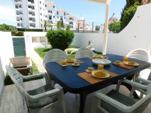 une table bleue et des chaises sur un balcon dans l'établissement Estrela Mar Marina Villa, à Quarteira