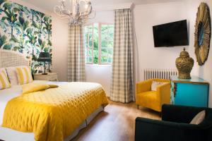 a bedroom with a yellow bed and a yellow chair at Hotel La Métairie - Les Collectionneurs in Mauzac-et-Grand-Castang