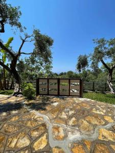 a stone patio with a fence and trees at Triantis Apartments in Ligia