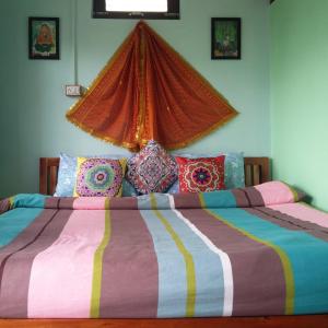 a large bed with a colorful comforter in a bedroom at Sharda Stay's Binsar Himalayas in Almora