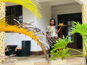 Una donna in piedi di fronte a un palazzo di KAMAO Hotel ad Arusha