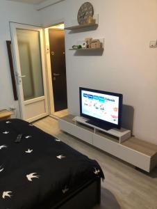 - un salon avec un lit et une télévision dans l'établissement Apartament situat aproape de mare, à Constanţa