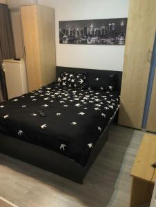 - une chambre dotée d'un lit noir avec des papillons blancs dans l'établissement Apartament situat aproape de mare, à Constanţa