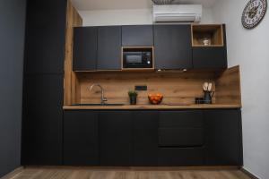 una cocina con armarios negros y fregadero en Apartments Residence Radovan 1, en Poreč