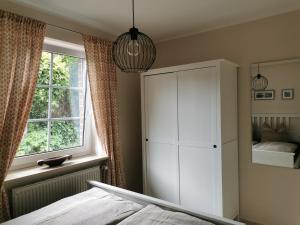 a bedroom with a white cabinet and a window at Entspannt Wohnen - vor den Toren Lübecks in Stockelsdorf