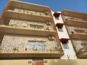 un edificio alto con ventanas con barrotes y plantas en A & A TERANGA en Somone