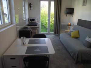 una sala de estar con un sofá y una mesa en Pétale de RoZ au pied du Mont Saint Michel, en Roz-sur-Couesnon