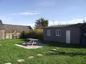 a backyard with a picnic table and a shed at Pétale de RoZ au pied du Mont Saint Michel in Roz-sur-Couesnon