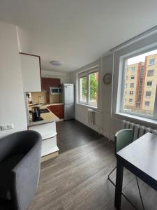 een kamer met een keuken met een tafel en een koelkast bij APARTMENTS IN THE CITY CENTER BIRŽAI Vytauto g22 in Biržai