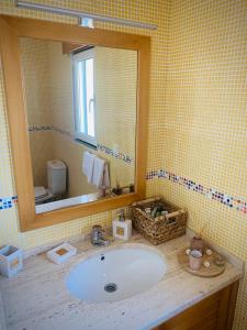 ein Badezimmer mit Waschbecken und Spiegel in der Unterkunft Porto Santo Casa Dourada in Porto Santo + 27 Fotos