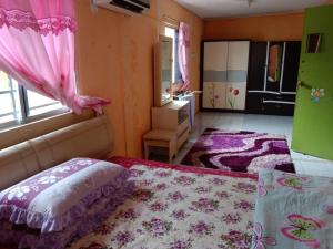 um quarto com uma cama e um espelho e cor-de-rosa cortinas em HOMESTAY AINNUR SEMARAK em Tawau