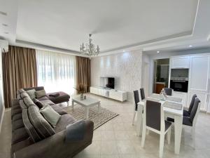 uma sala de estar com um sofá e uma sala de jantar em Aquamarine Apartments em Saranda