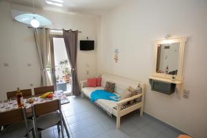 a small living room with a couch and a table at Rania Studios in Gouves