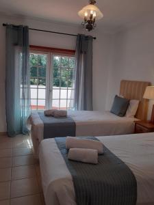 sypialnia z 3 łóżkami i oknem w obiekcie Casa da Praia - Golf Resort Praia D'El Rey w mieście Amoreira