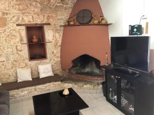 a living room with a fireplace and a tv at Friendly villagehouse in Paphos City