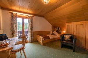 a bedroom with a bed and a desk and a chair at Landhaus Ertle in Bad Wiessee