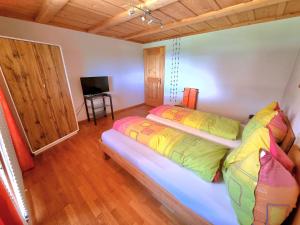 a bedroom with two beds and a flat screen tv at Lodge 24 in Illiswil