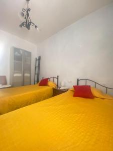 two beds in a room with yellow sheets at AMPLIO y CÉNTRICO APARTAMENTO - AVENIDA DE MIJAS - MARENOSTRUM in Fuengirola