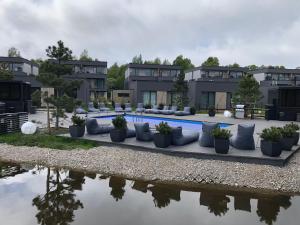 a pool at a resort with pillows next to a body of water at SUN HOME in Palanga