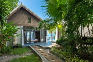 a house with a pathway leading to the front door at Beach Front Villa in Ban Bang Po