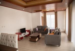 sala de estar con 2 sillas y TV en Millennium Apartments, en Kigali