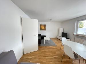 ein Wohnzimmer mit einem weißen Tisch und Stühlen in der Unterkunft FeWo "Obere Bündt" in Konstanz