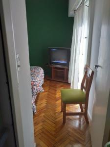 a living room with a television and a chair at Carlos Calvo in Buenos Aires