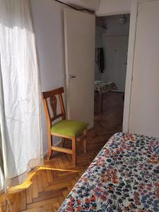 a room with a chair and a bed and a window at Carlos Calvo in Buenos Aires