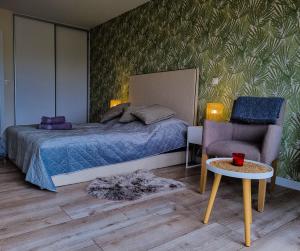 a bedroom with a bed and a chair and a table at Bałtyk 44 na Wydmach in Międzywodzie