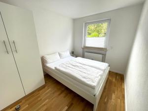 a small bedroom with a bed and a window at FeWo "Obere Bündt" in Konstanz