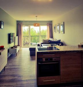 a living room with a kitchen and a couch at Bałtyk 44 na Wydmach in Międzywodzie