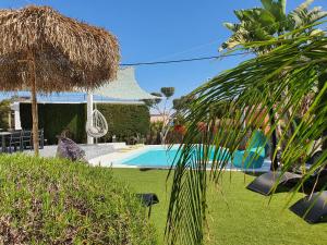a resort with a swimming pool and a straw hut at MAS BLANC in Calafell