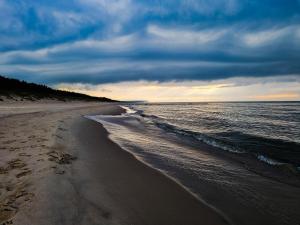 una playa con un cielo nublado y el océano en Apartament Bałtycka Ostoja Na Wydmach en Międzywodzie