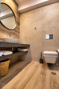 a bathroom with a sink and a toilet and a mirror at Nostalgia Suites in Faliraki