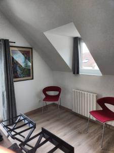 een woonkamer met rode stoelen en een raam bij Le Val d'Andé in Andé