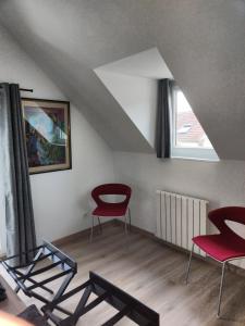 a living room with red chairs and a window at Le Val d'Andé in Andé